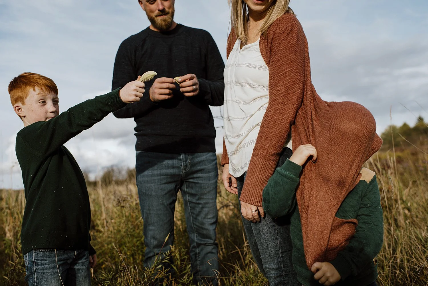 fall photo session with family of two brothers in a field at sunset