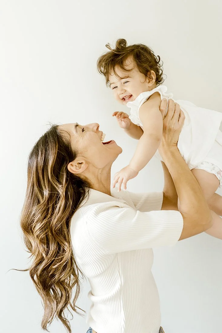 mom with baby on white wall photo session at toronto home