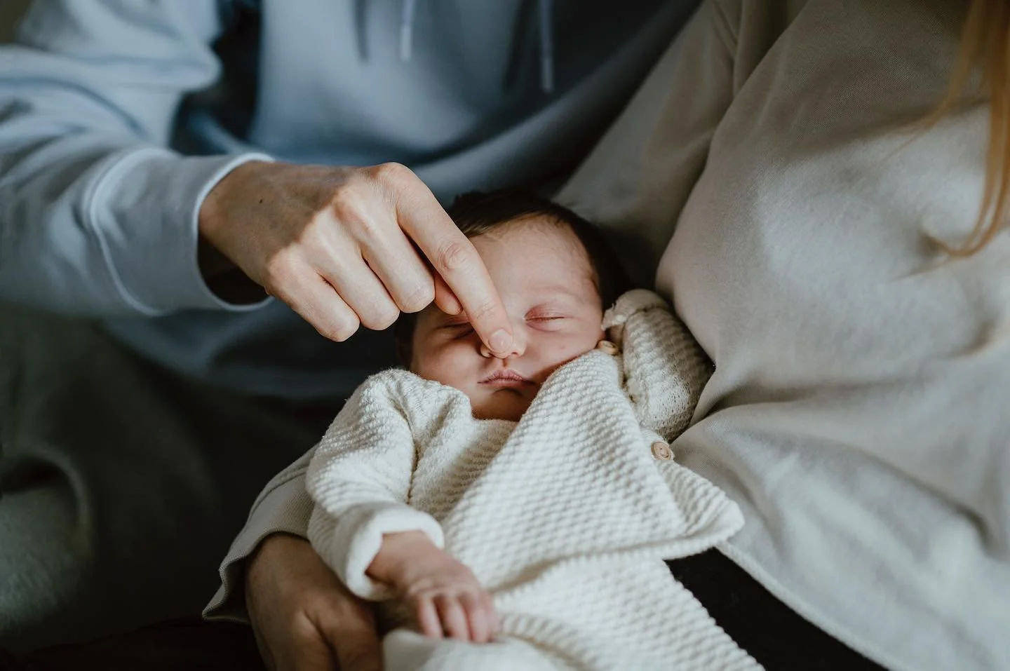 Dad is booping the nose of his brand new baby at their home