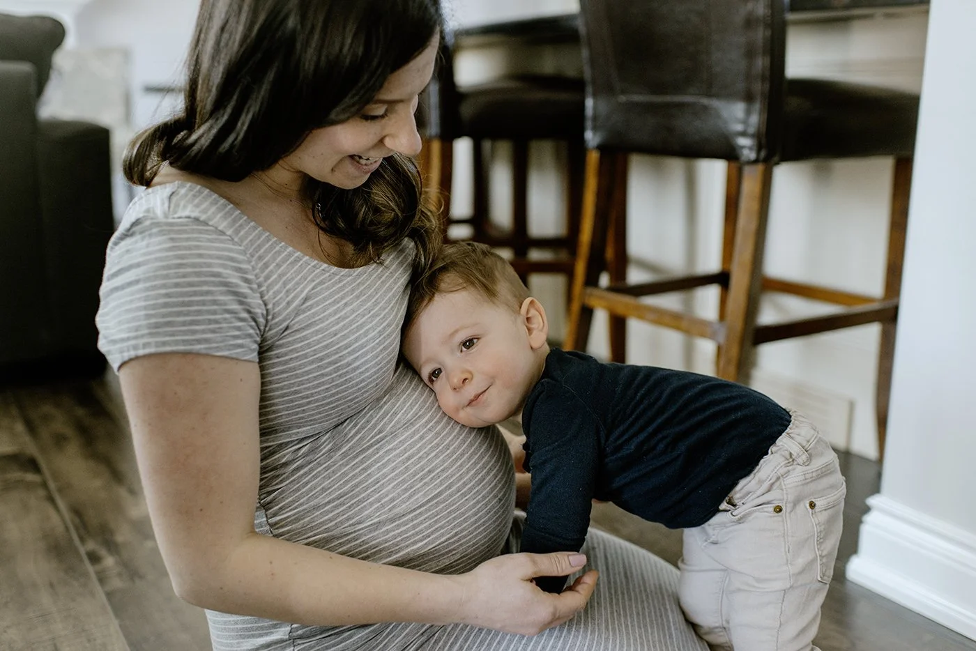 maternity toronto photographer photo of brother leaning his head on his mothers stomach