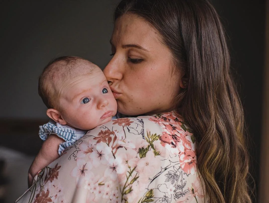A Fresh 48 session of a toronto mom holding her brand new baby at home in the nursery