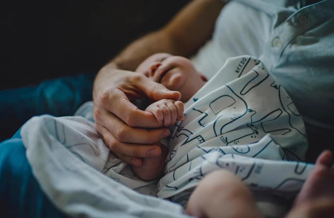 A fresh 48 session taken at a toronto home of a mom holding the hand of their newborn baby