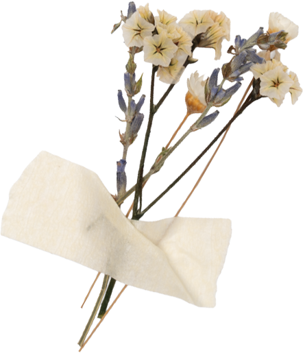 A small bouquet of artificial white and purple flowers held in beige tissue paper.