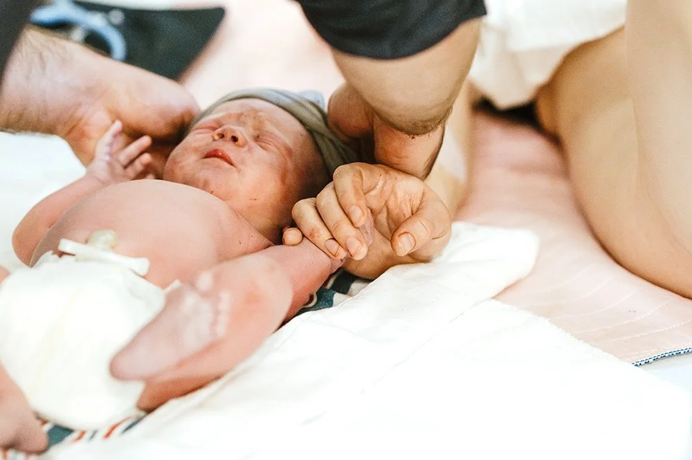 newborn baby holding moms hand