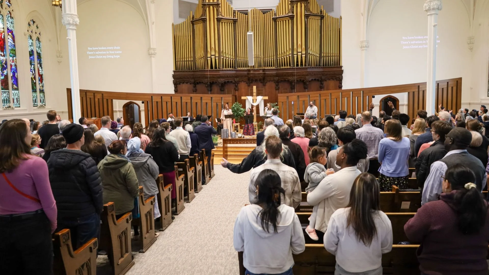 a sanctuary full of a diverse group of people worshipping inside the Knox church sanctuary