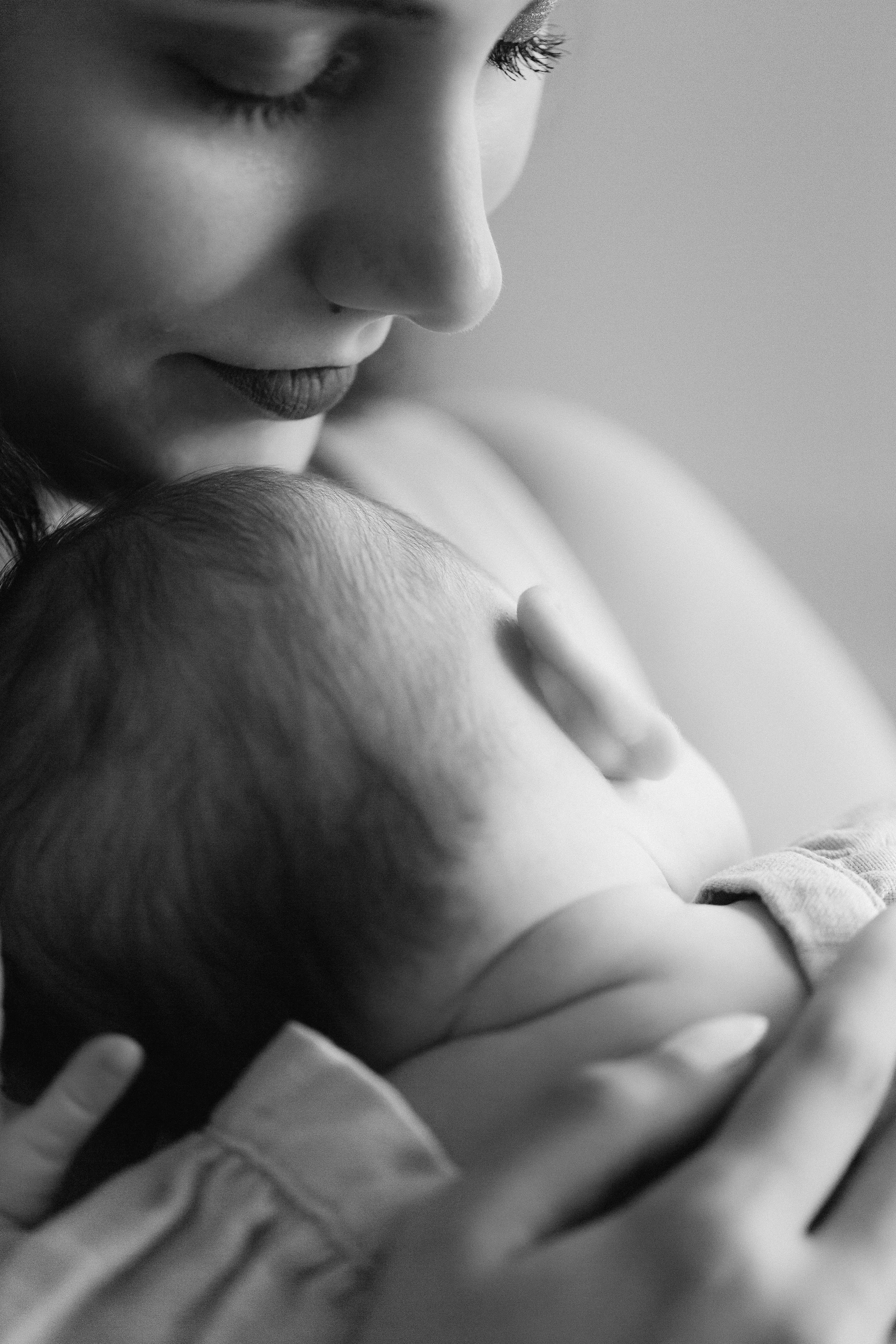 Close-up of a woman holding a newborn baby, photographed by Maison Mancel in-studio in NYC.