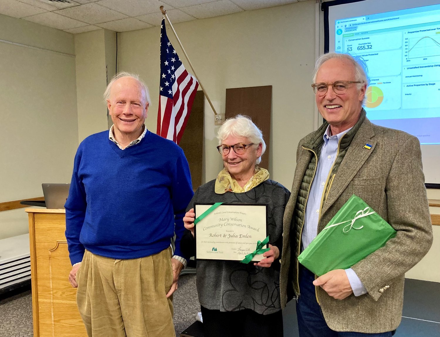  Willit Mason, VP for SLCT, (on left) presents the Mary C Wilson Award to Julia and Rob Emlen of Seekonk. 