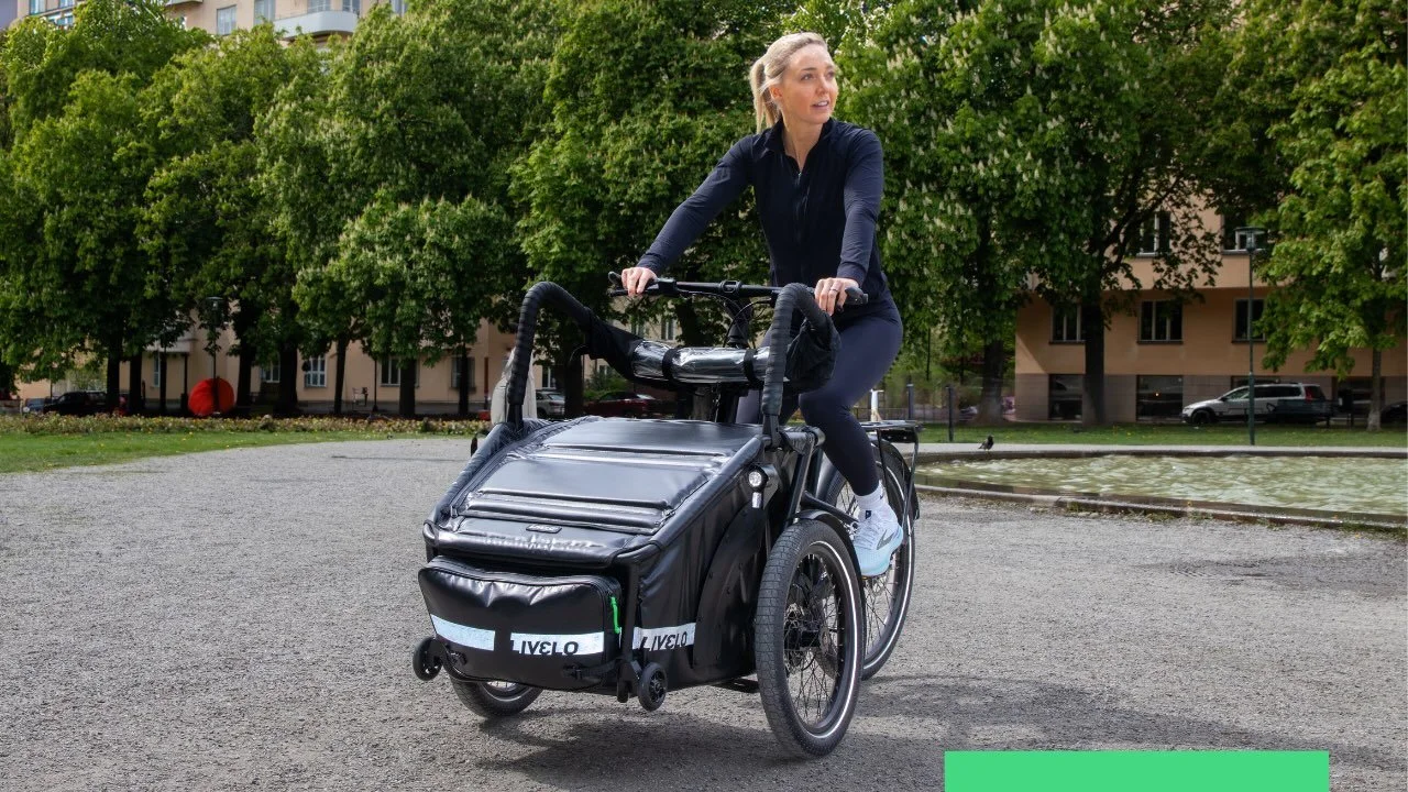 Kvinna i stockholm, cyklar på lådcykel, trehjuling svart premium cykel