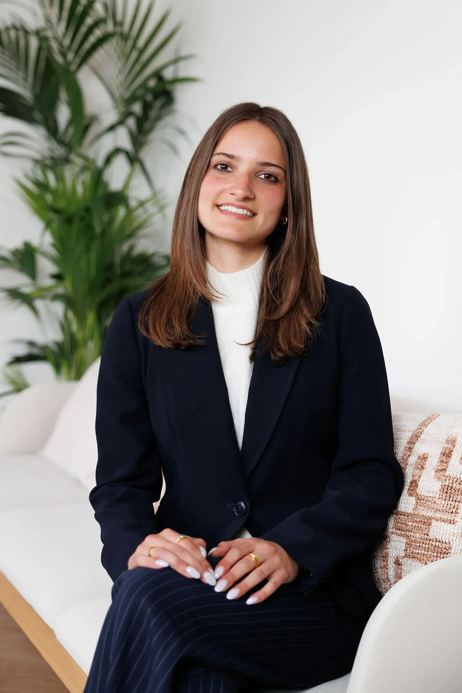 Sampson Fielding Tax Associate Jennifer Read smiling and sitting on a sofa at their Central London advisory practice