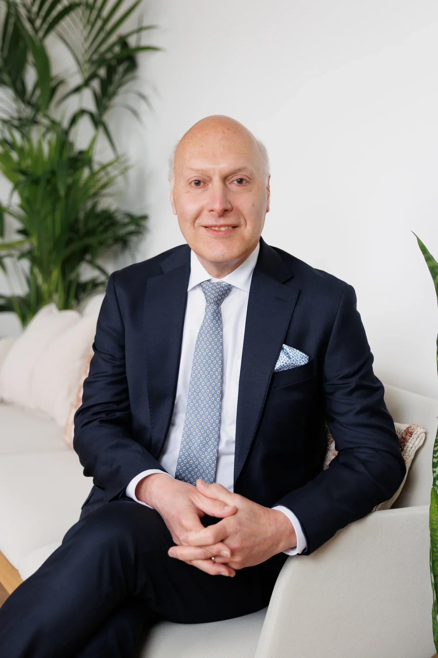 Sampson Fielding Partner Simon Kinna FCCA smiling and sat on a couch at their chartered accountancy firm in Central London