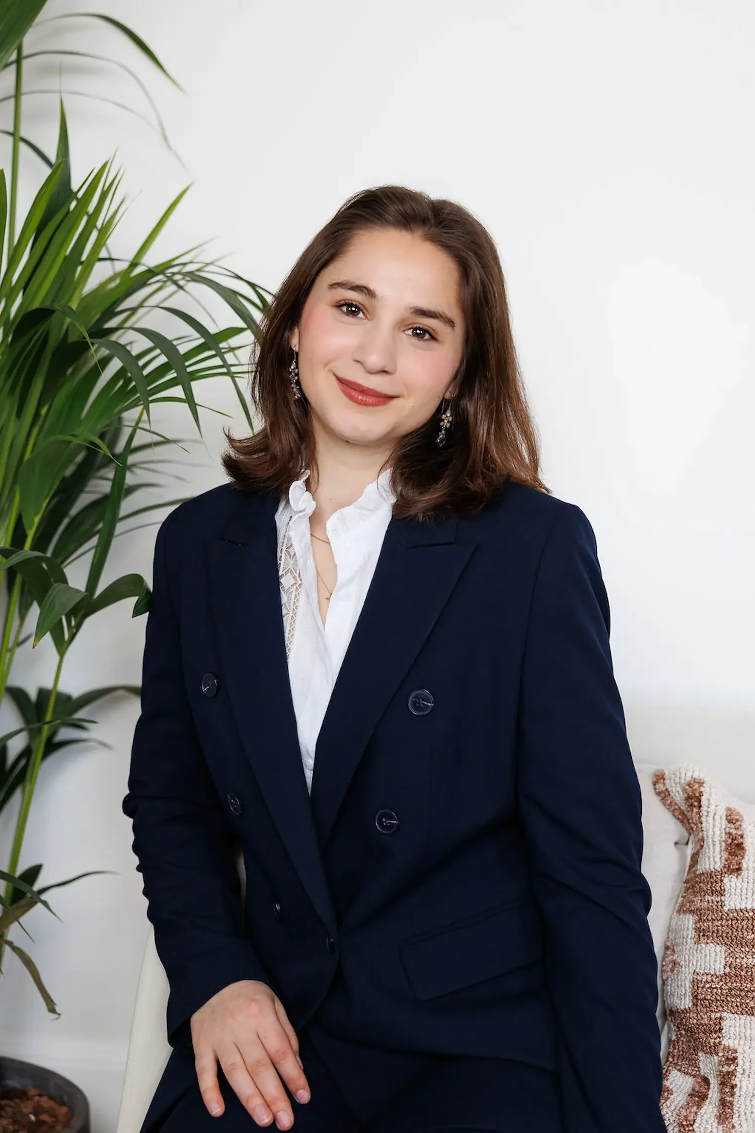 Sampson Fielding Associate Alexandra Thomson-Glover smiling and sitting on a chair at their Central London practice