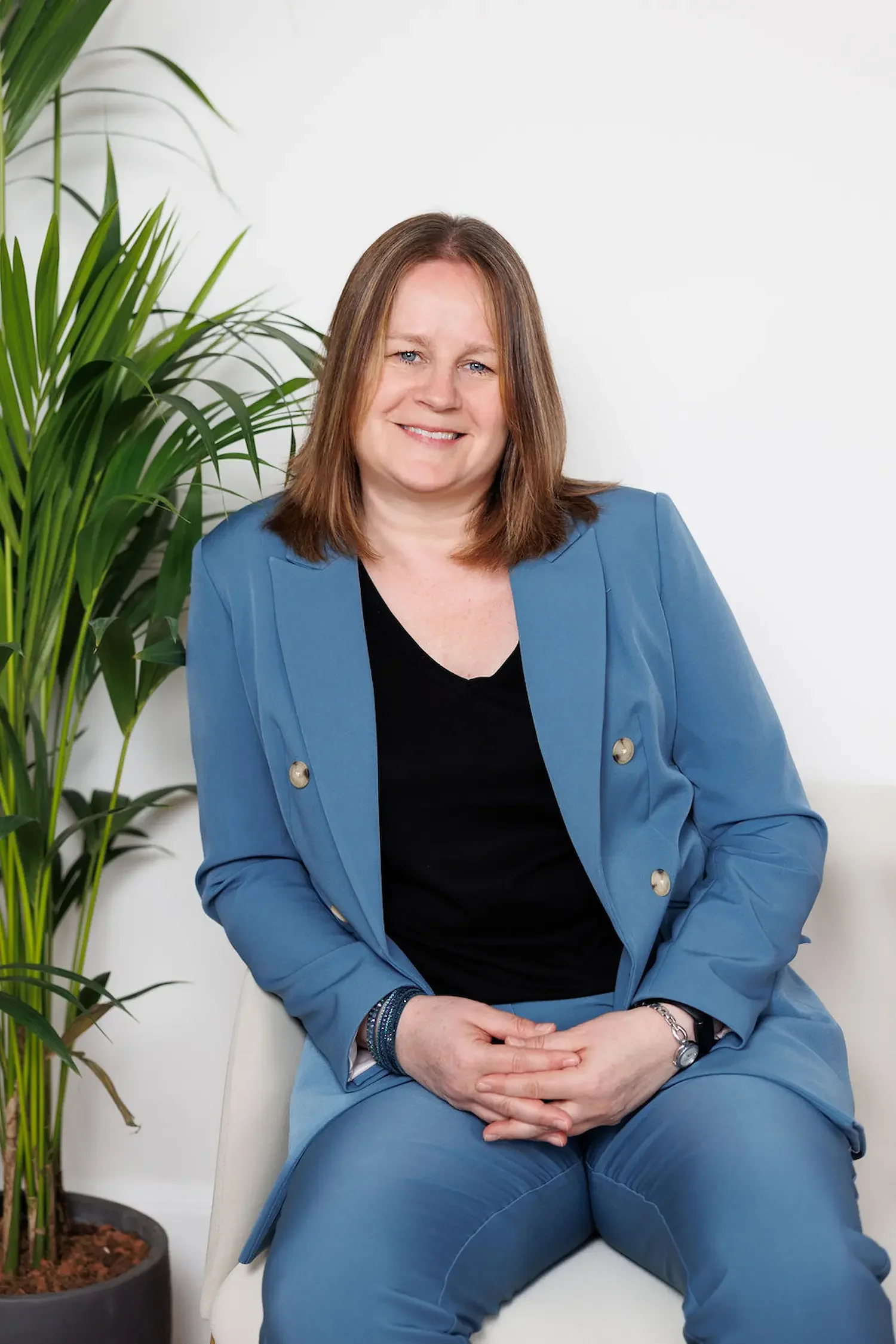 Sampson Fielding Partner Lyndsay Pester FCA smiling and sitting on a chair at their chartered accountancy firm in Central London
