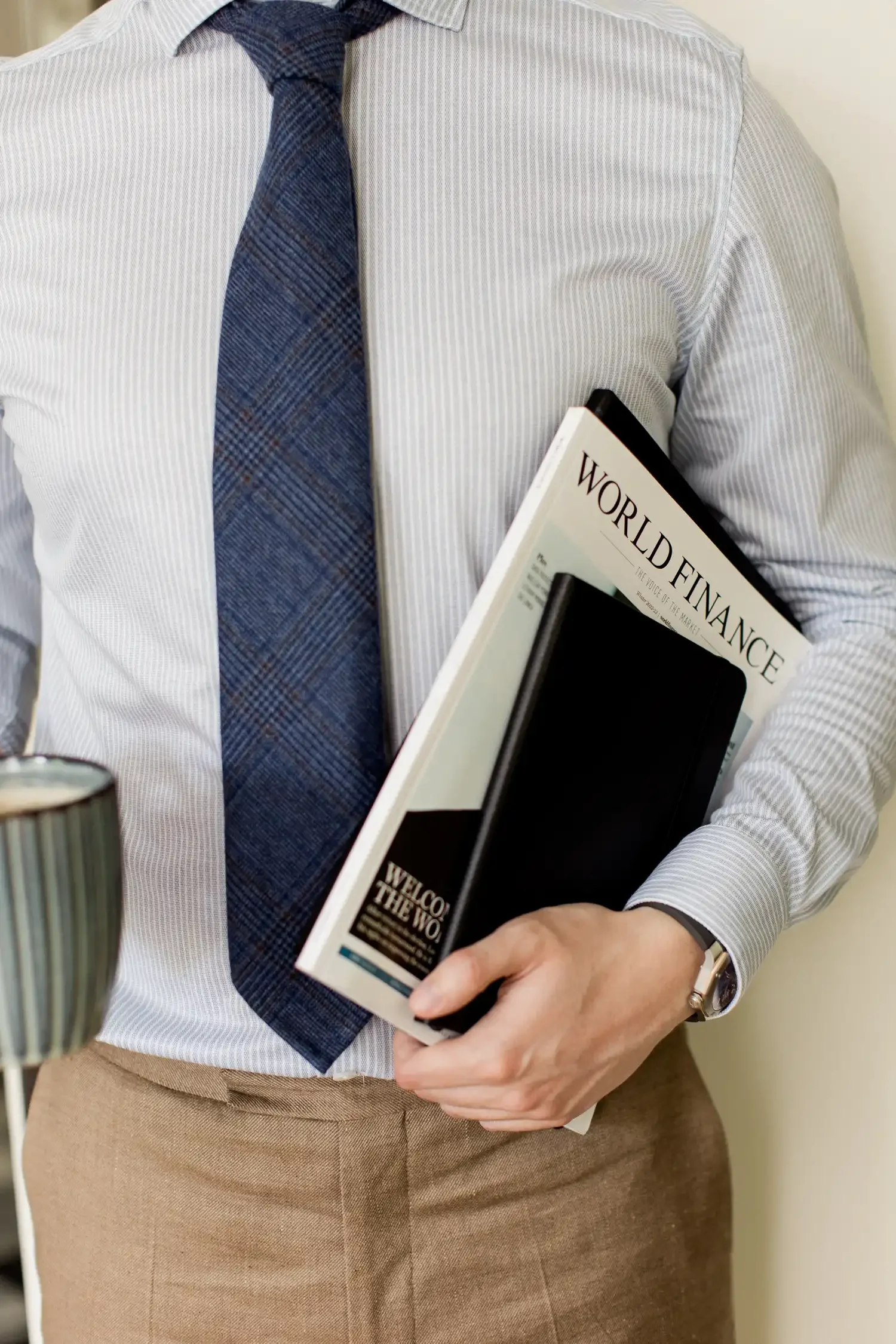 Close up of Sampson Fielding COO Craig Jones holding a World Finance magazine and notebook at his Central London practice