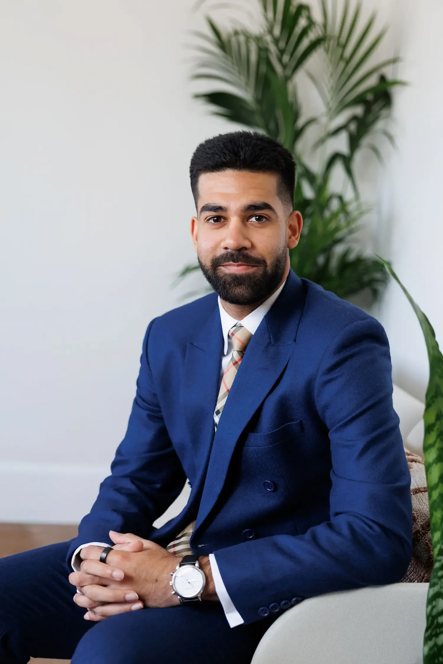 Sampson Fielding Senior Associate Asher Ahmed sitting on a chair at their Central London business advisory practice