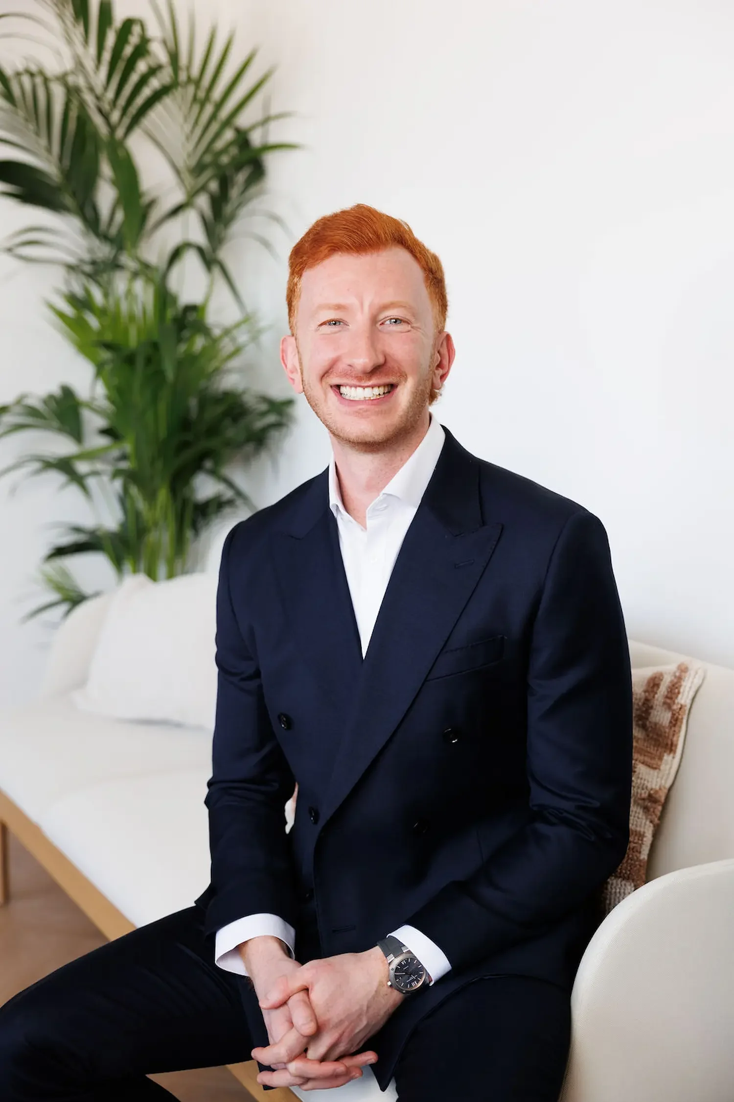 Sampson Fielding Partner Giordan Boston ACA smiling and sitting on a sofa at their chartered accountancy firm in Central London