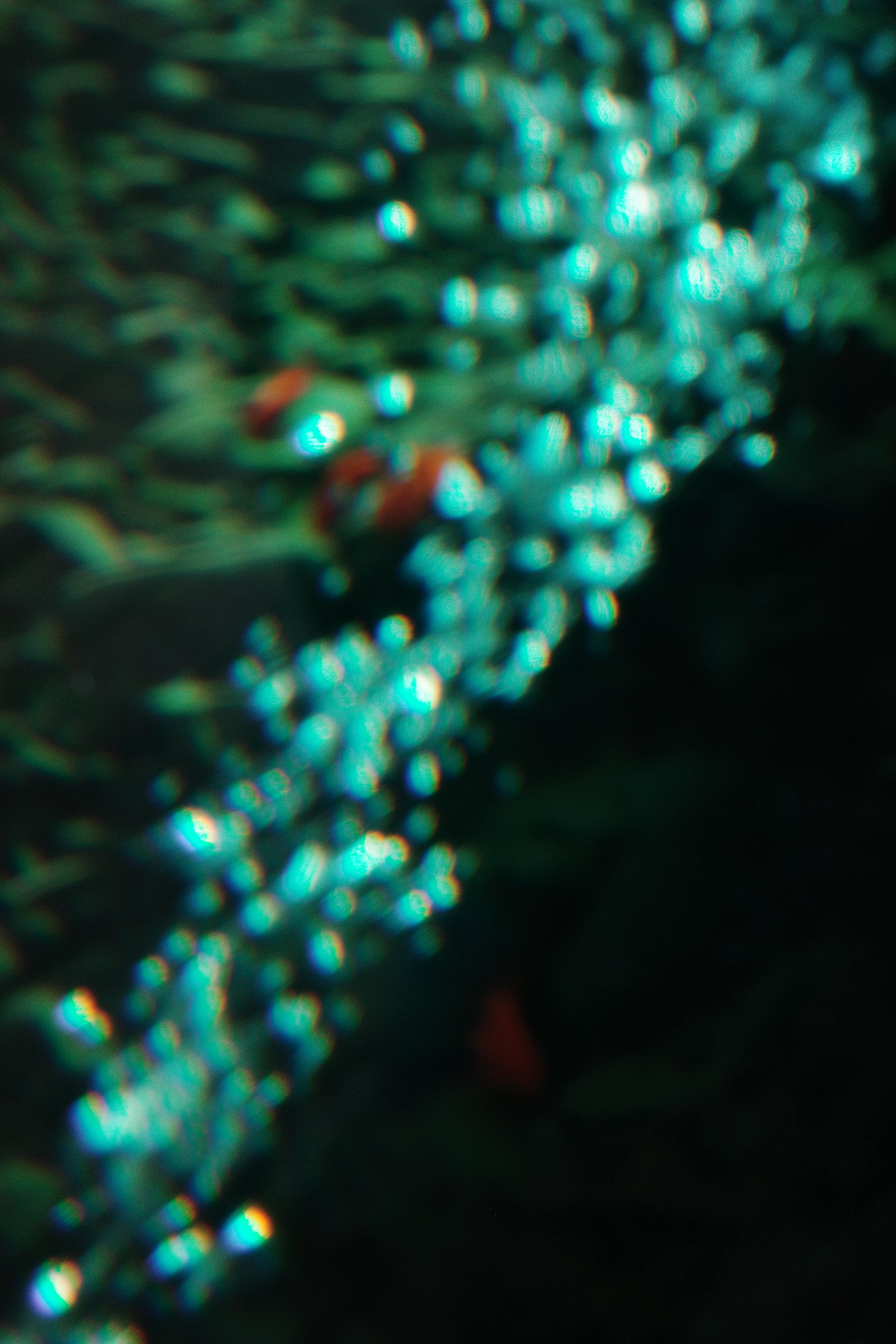 Close-up of a sparkling, beaded jewelry piece, possibly a necklace, with a bokeh effect creating a luminous, shimmering appearance.