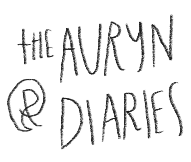 Handwritten text reads "The Auryn Diaries" on a black background.