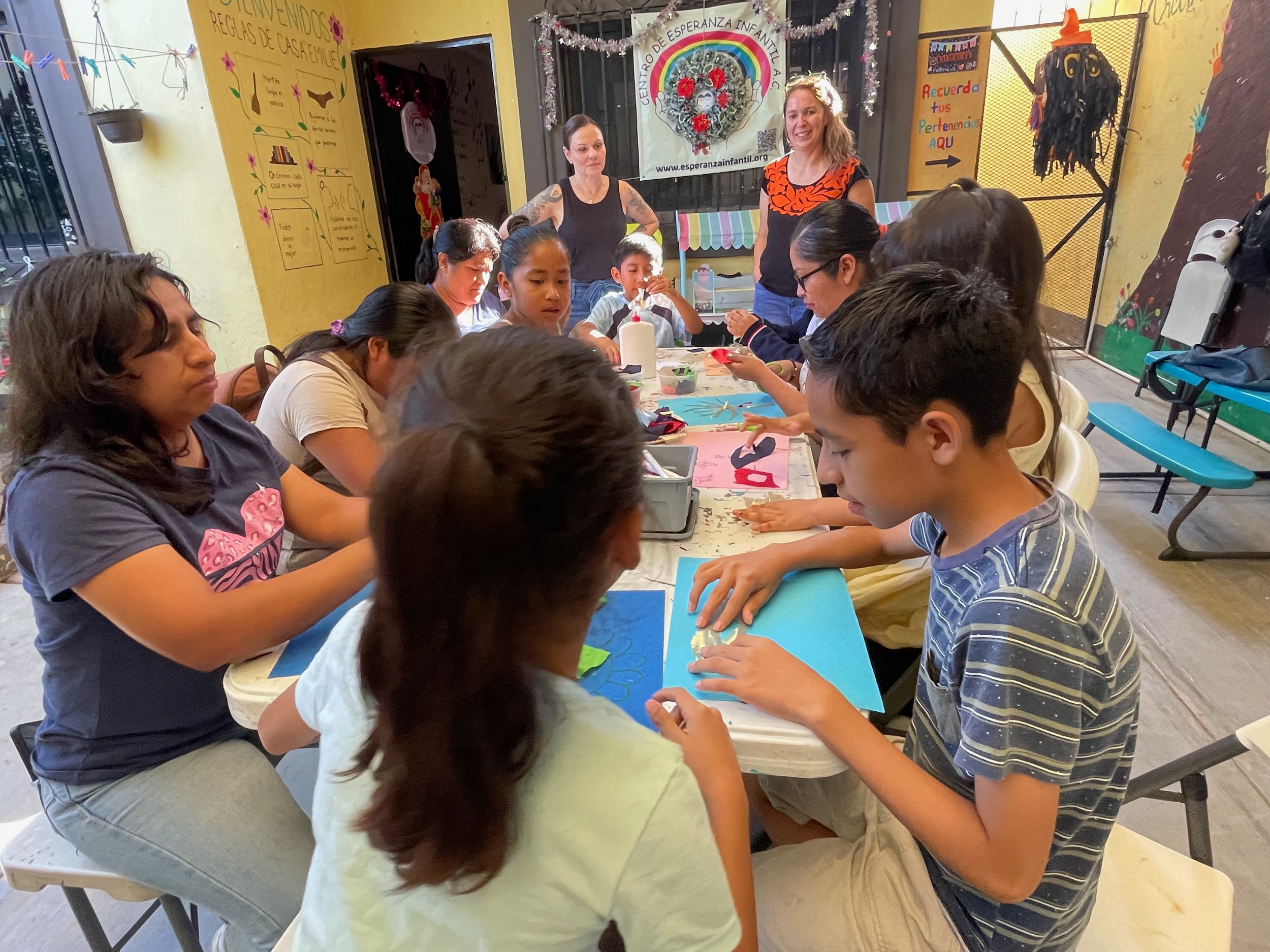 Community room setup for CoMadres group session with chairs arranged in supportive circle. group therapy setting, community space, circle format