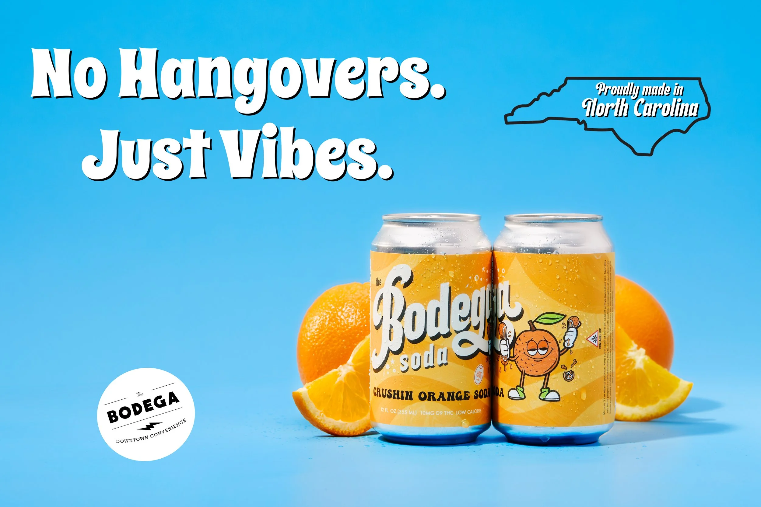 Two cans of The Bodega Crushin Orange Soda with oranges and orange slices in the background against a blue backdrop. Text says, 'No Hangovers. Just Vibes.' and a North Carolina map outline with 'Proudly made in North Carolina.'