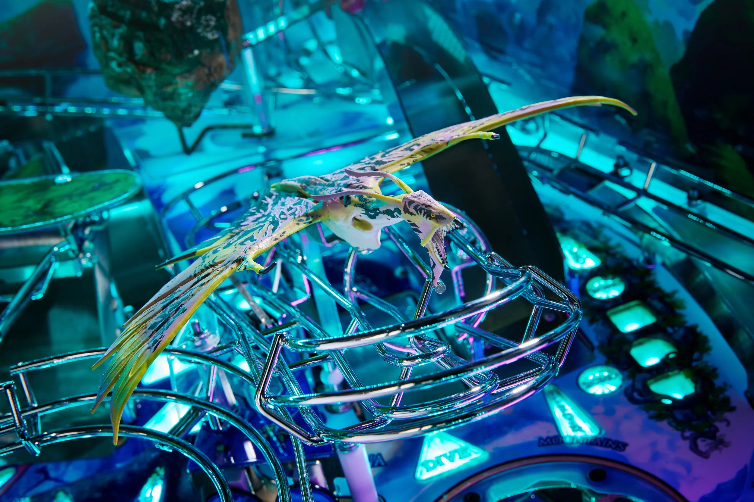 A pinball machine featuring a dragon-themed design with a dragon figure mounted on the playfield, illuminated by vibrant blue, green, and purple lights.