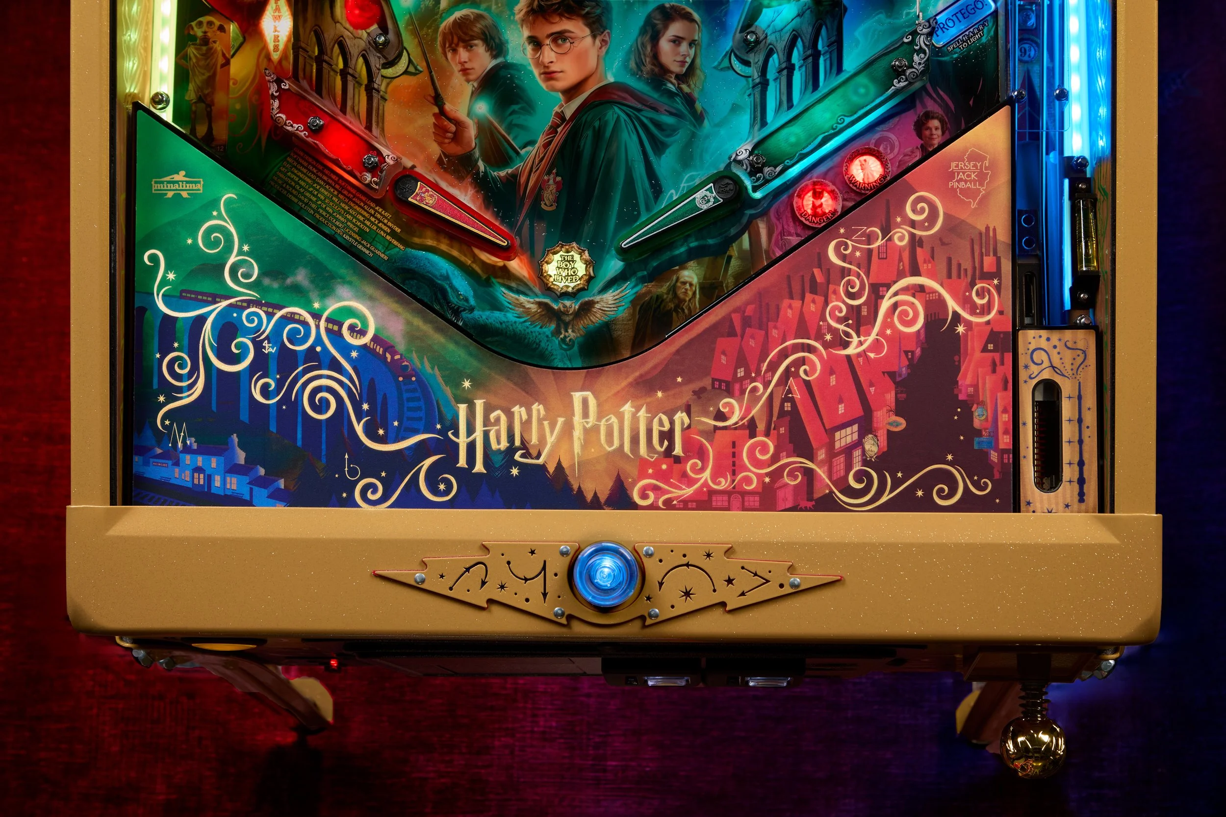 Close-up of a Harry Potter-themed pinball machine with artwork of Harry, Ron, and Hermione, and colorful glowing lights.
