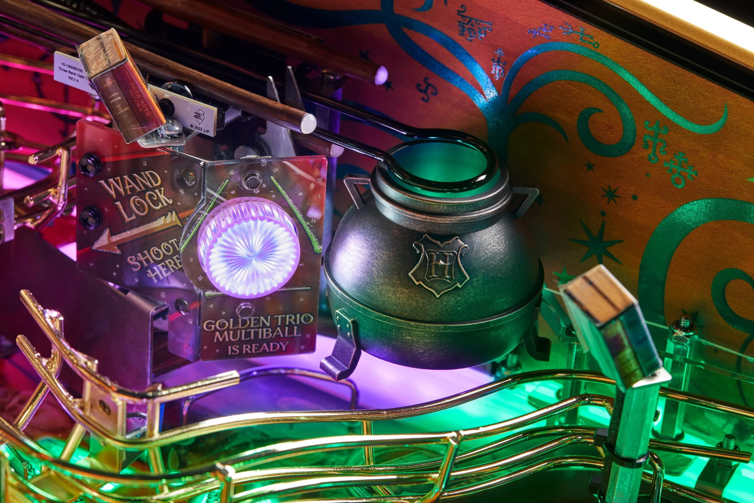 A multiball pinball machine with a colorful, illuminated playfield featuring a green cauldron, a mirror with purple light, and a sign that reads 'Wand Lock Shoot Here.'