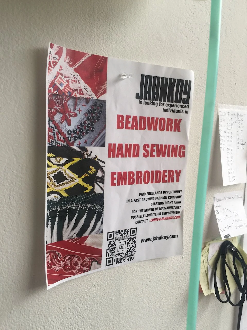 Flyer on a wall advertising job opportunities in beadwork, hand sewing, and embroidery for a fast-growing fashion company. It includes contact information, a QR code for more details, and images of textiles.