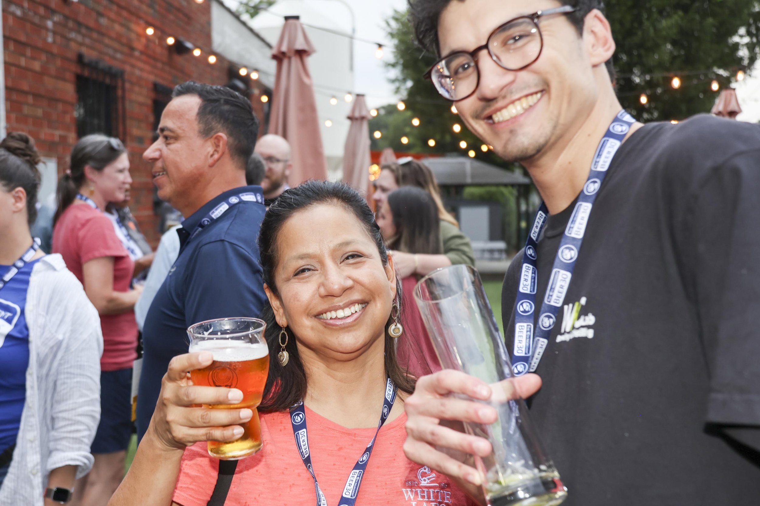 two people smiling and holding beer