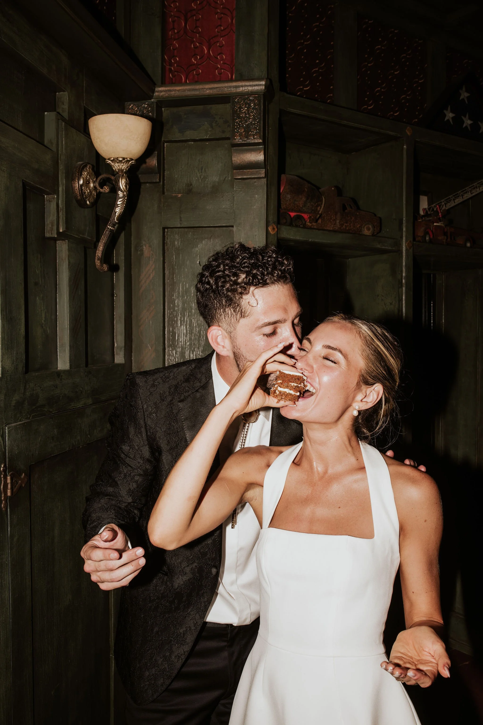 Couple in wedding attire sharing a dessert
