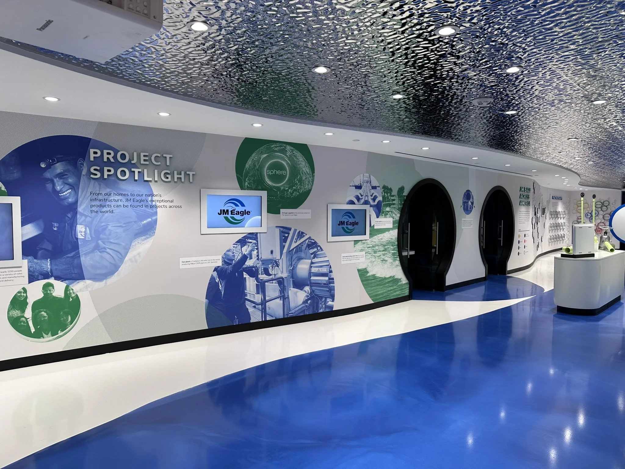 Graphic wall showcasing major projects with conference cubbies.
Image Credit: Bridgewater Studio
