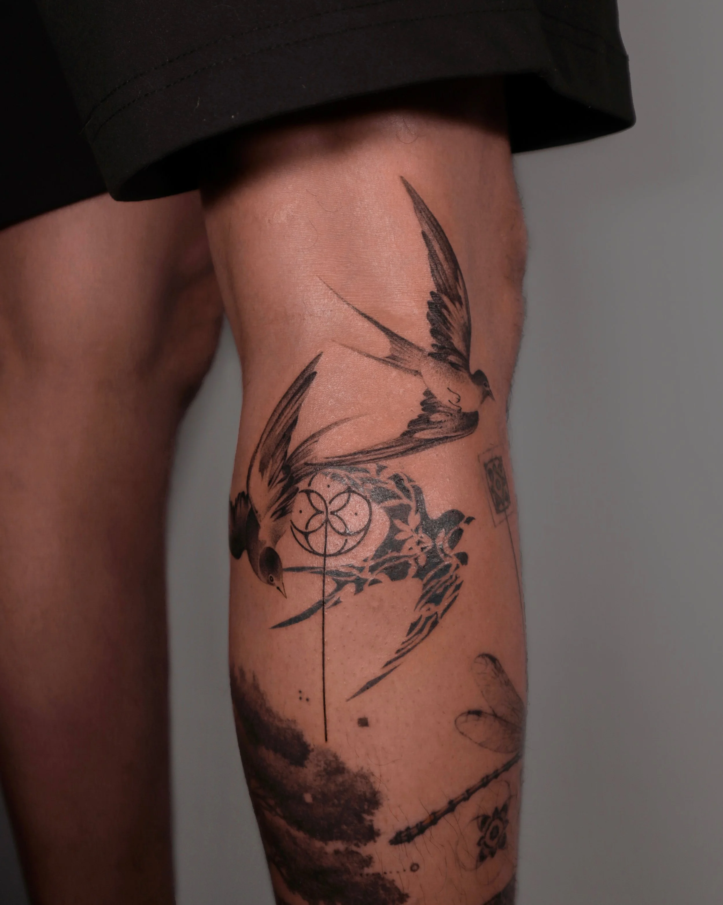 Close-up of a person's arm with a large, detailed butterfly tattoo featuring dark wings and wing patterns.
