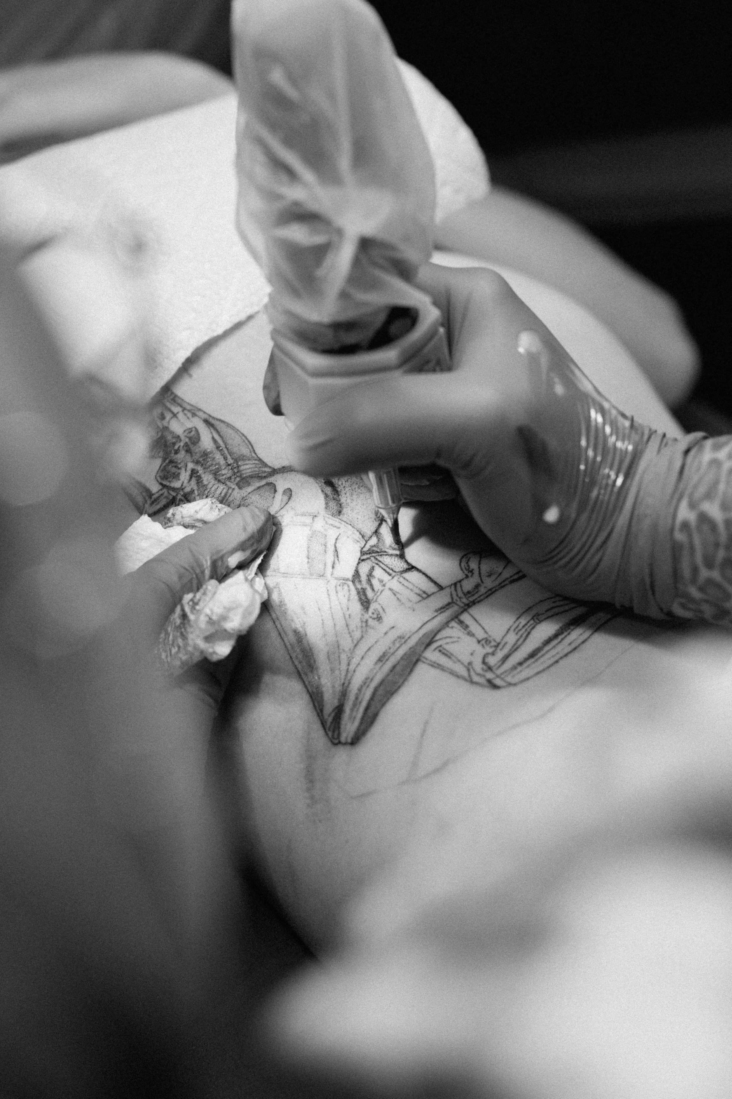 A person in gloves drawing a detailed image of a woman on paper using a pen.