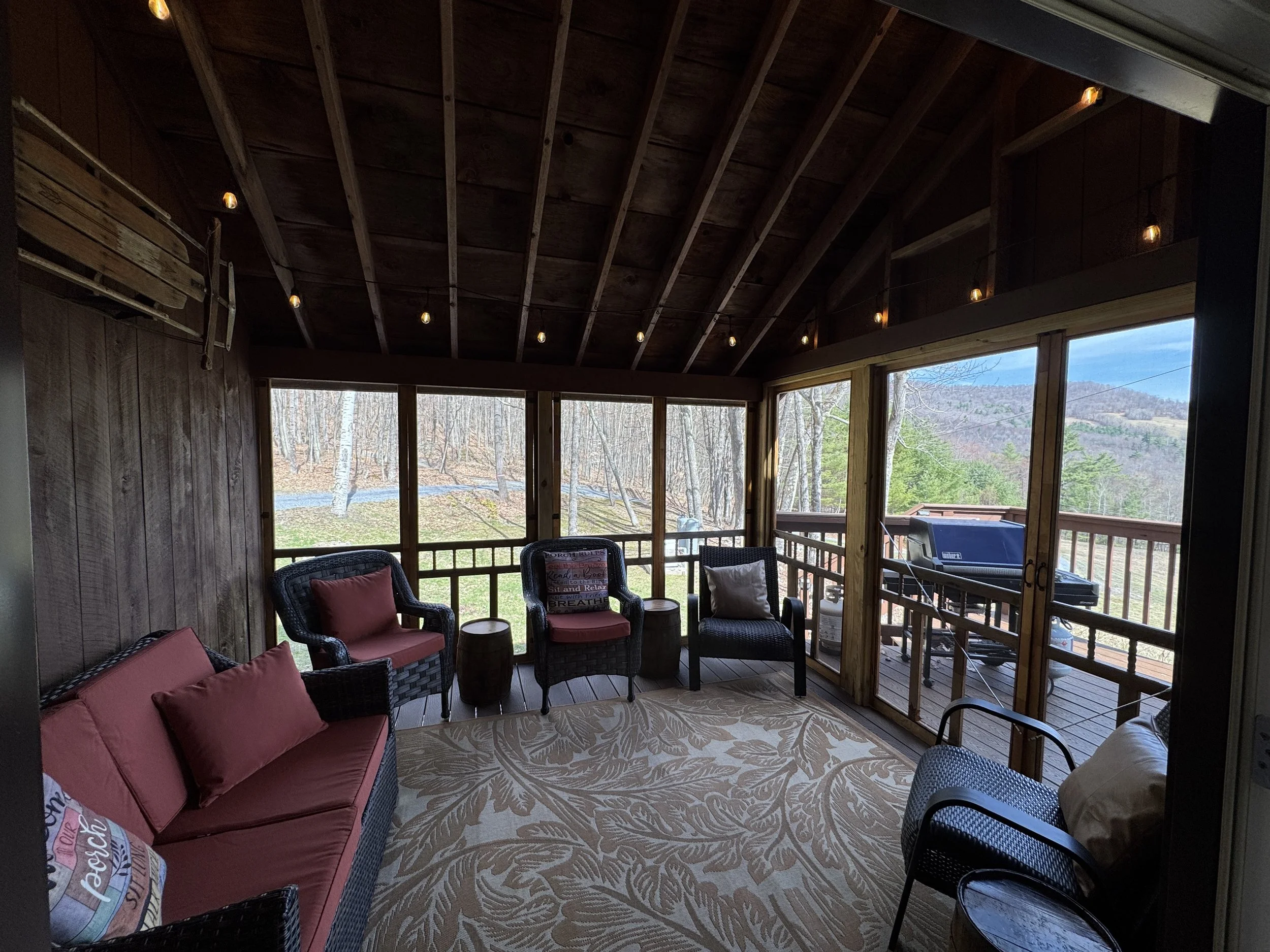 Porch leads to gas grill and wrap-around deck