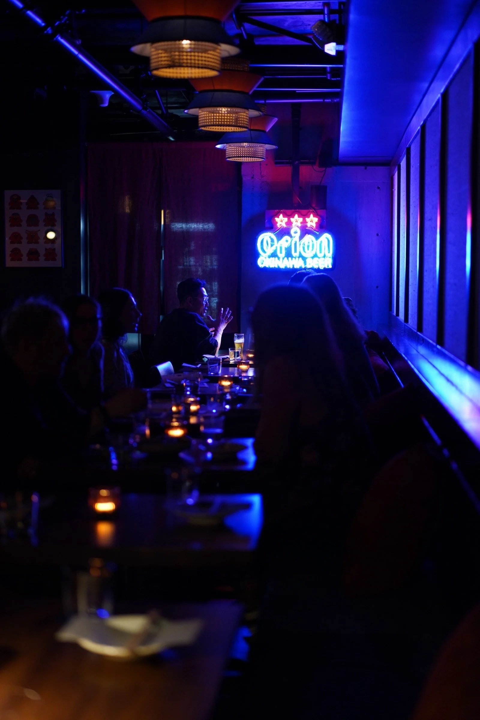 Budonoki bar glowing blue under an Orion beer neon sign