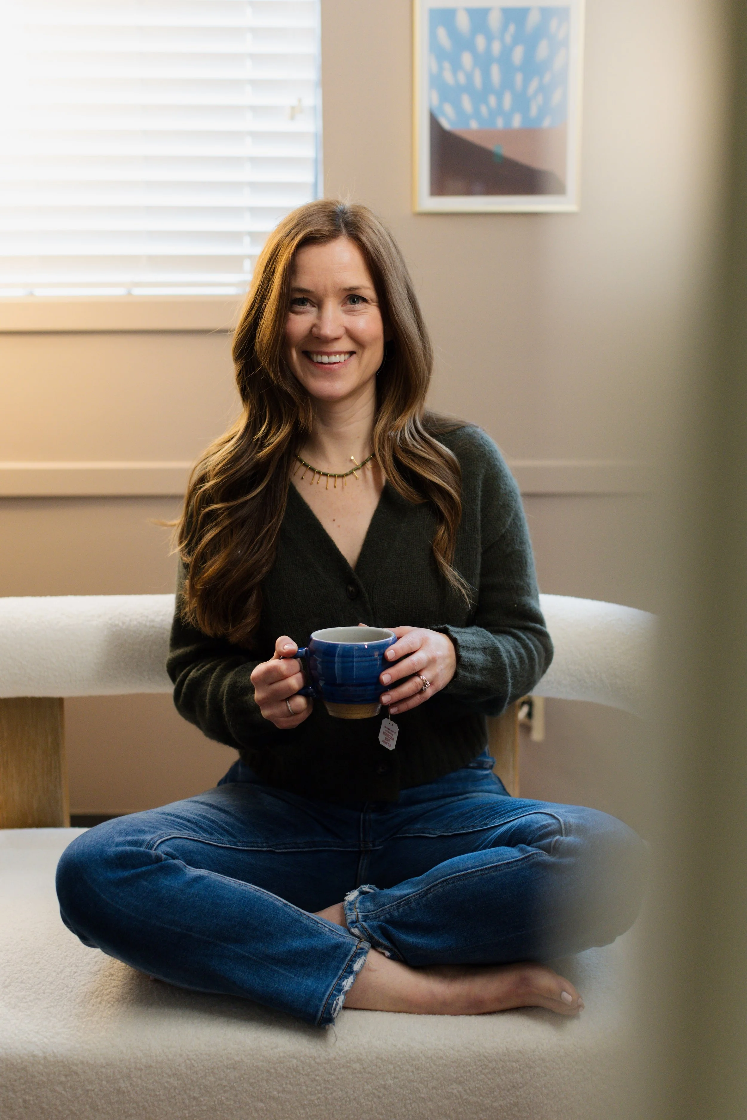 woman sitting on a modern couch drinking tea