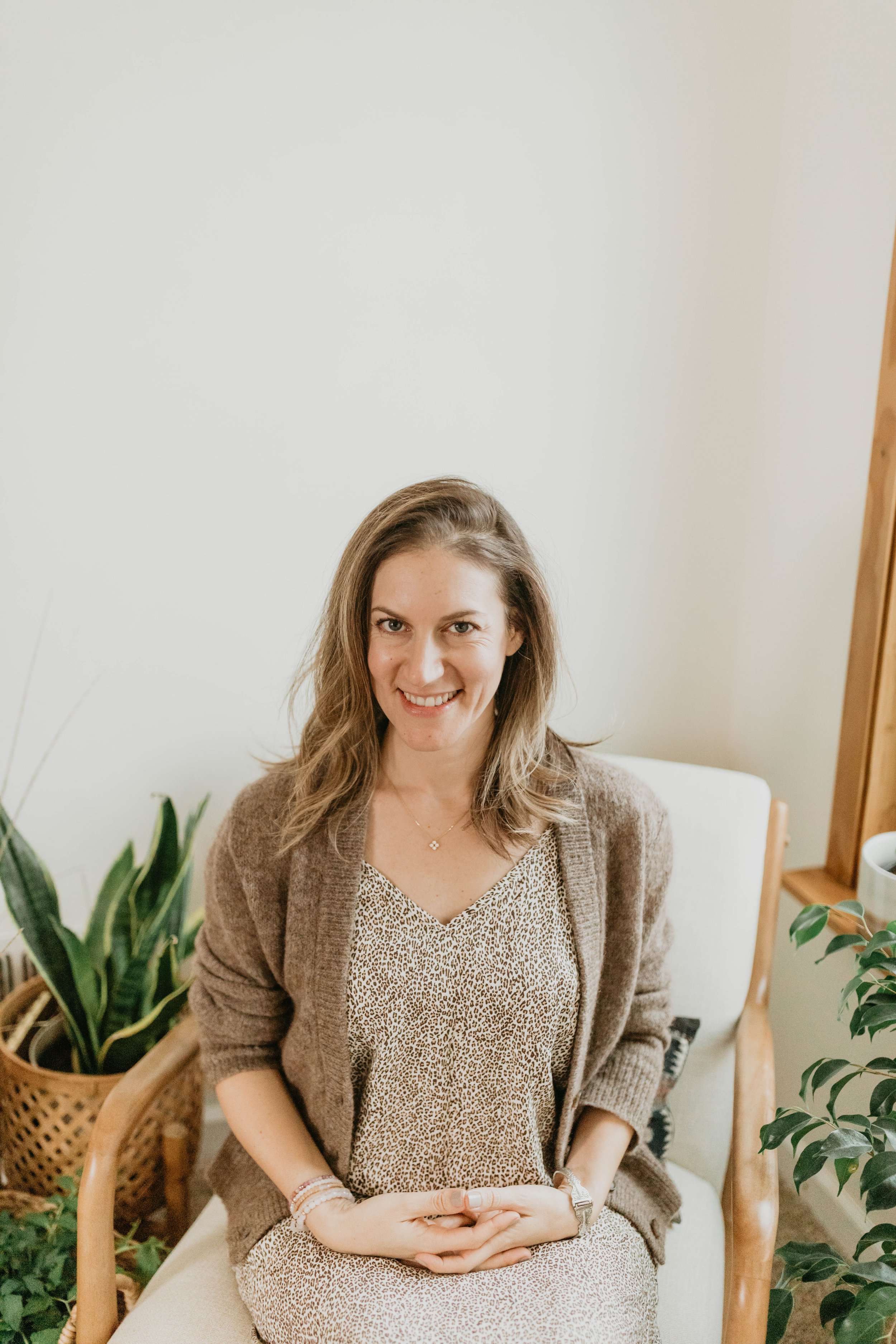 lifestyle headshot of a women sitting in an office setting with green plants