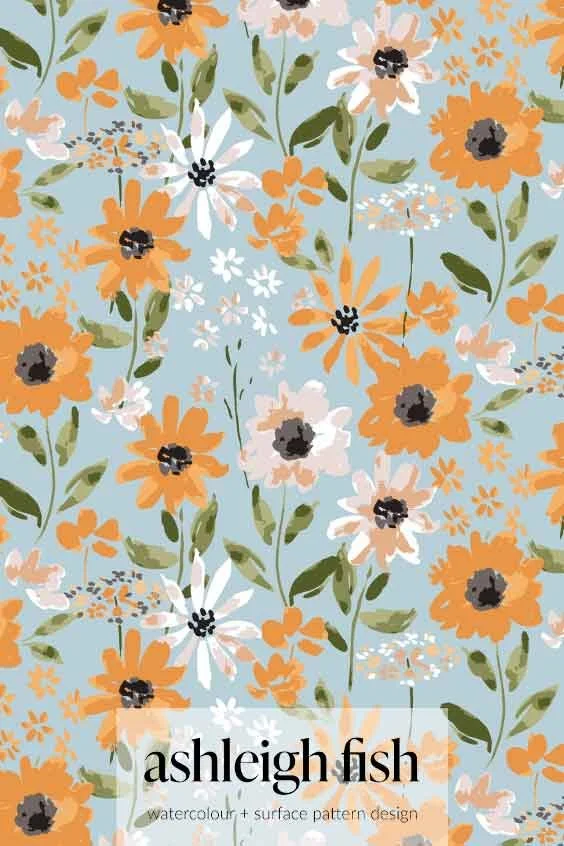 Floral pattern with orange and white flowers on a blue background, featuring green leaves. Design by Ashleigh Fish labeled as watercolor and surface pattern design.