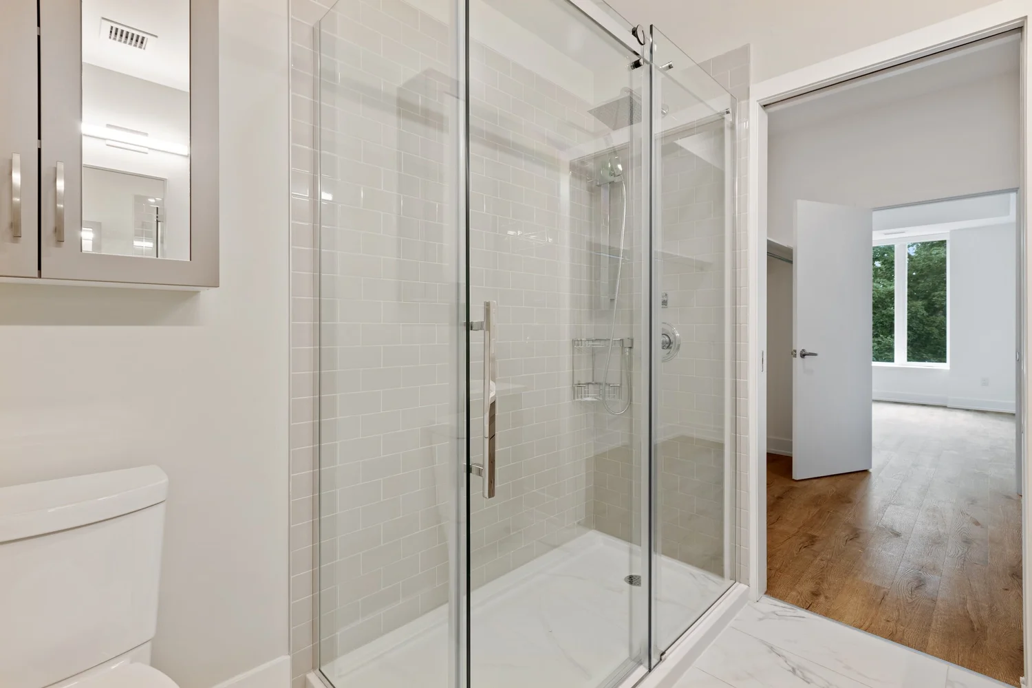 Residential bathroom with frameless shower screen, clear glass door and tiled walls