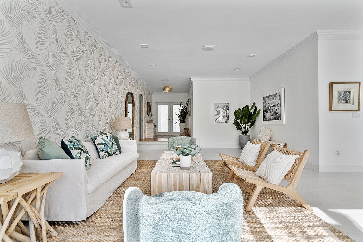 Living room with palm wallpaper and rattan chairs in a Coconut Grove, Miami home designed by Naomi Satya Interiors