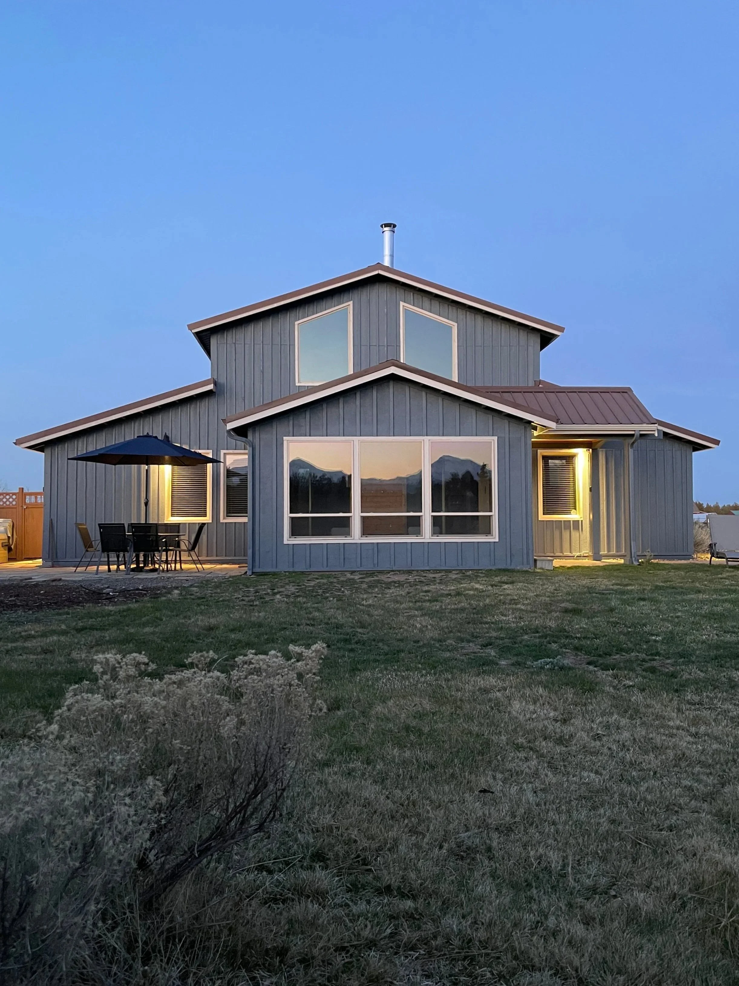 Image of the Barndominium with reflection of the Sisters mountains in the window at Six Mountain View vacation rental in Sisters, Oregon