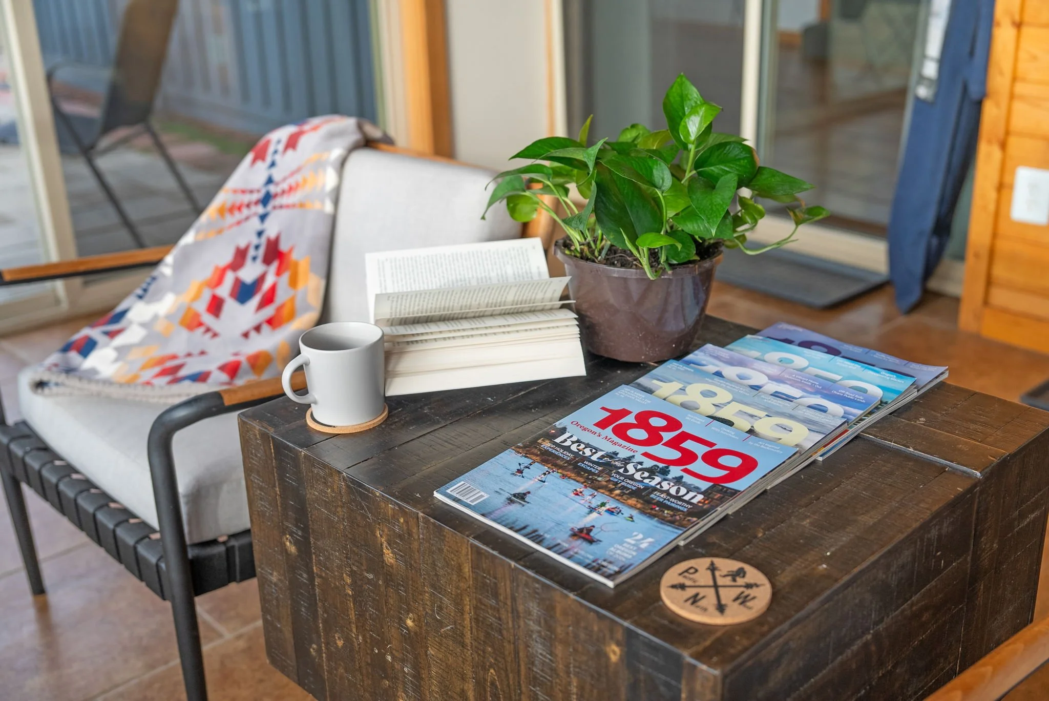 Image sun room with an open book and a mg of hot tea overlooking the Three Sisters mountains