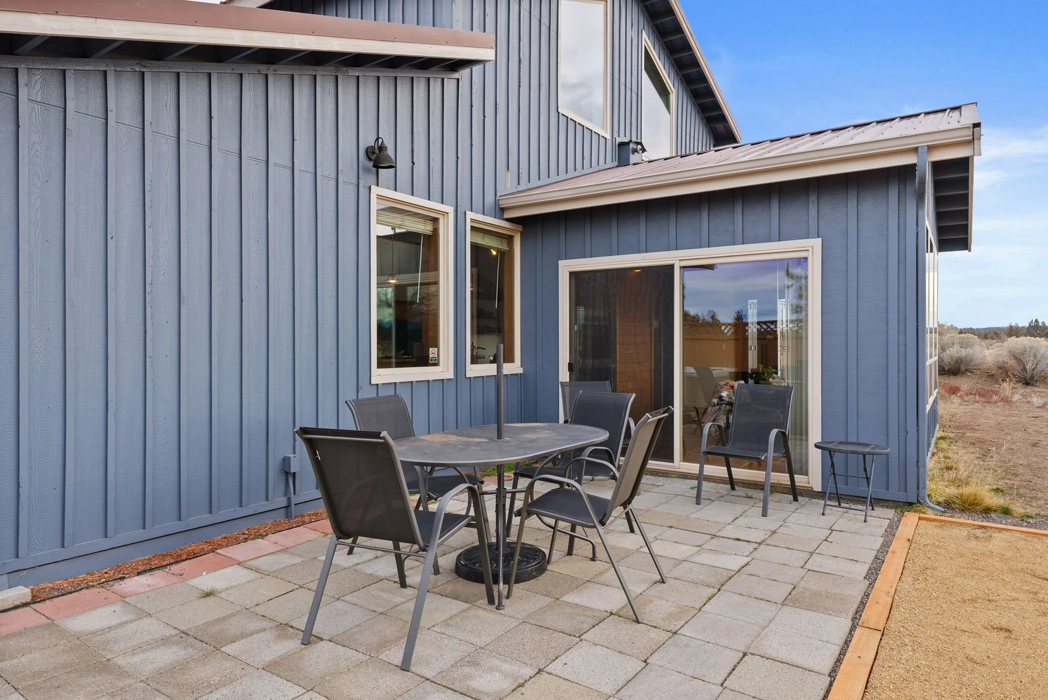 Patio with dining table and chairs looking towards the sun room