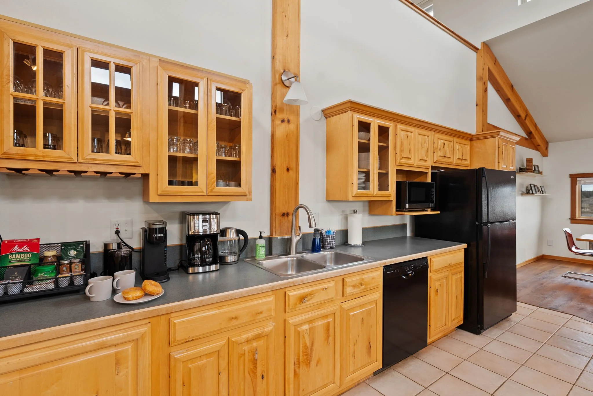 Photo of the kitchen at Six Mountain View showing coffee & tea station, sink, dishwasher and fridge