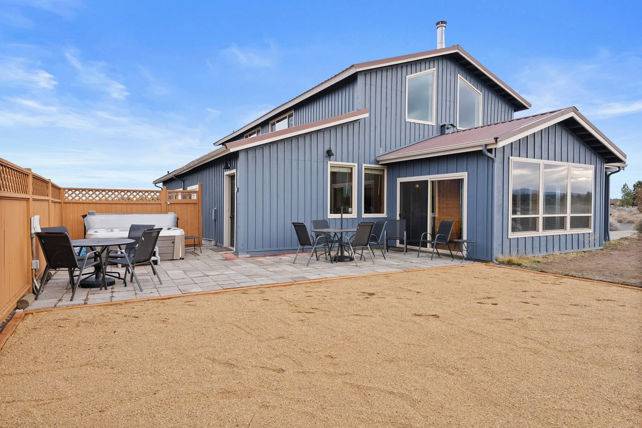 Shot of the exterior of the Barndominium showing the hot tub, patio and outside games area