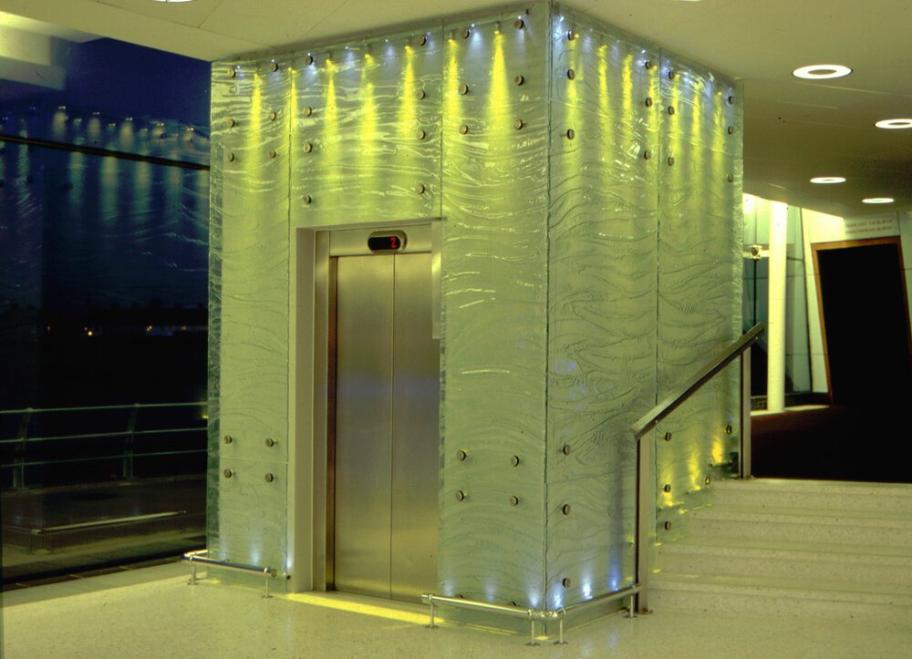Elevator in Newport Riverfront Theatre featuring slumped glass panelling.