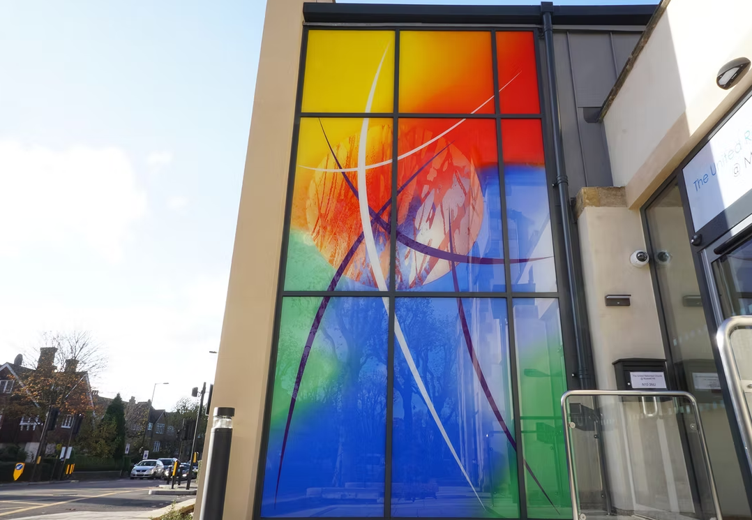 Modern stained glass opaque colourful church window and facade.