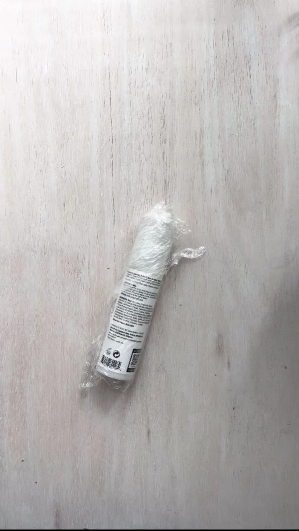 Tube wrapped in plastic wrap, prepared as a mold for DIY napkin rings made with paper pulp.
