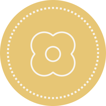 A gold-colored coin with a stylized flower design in the center and dotted border.