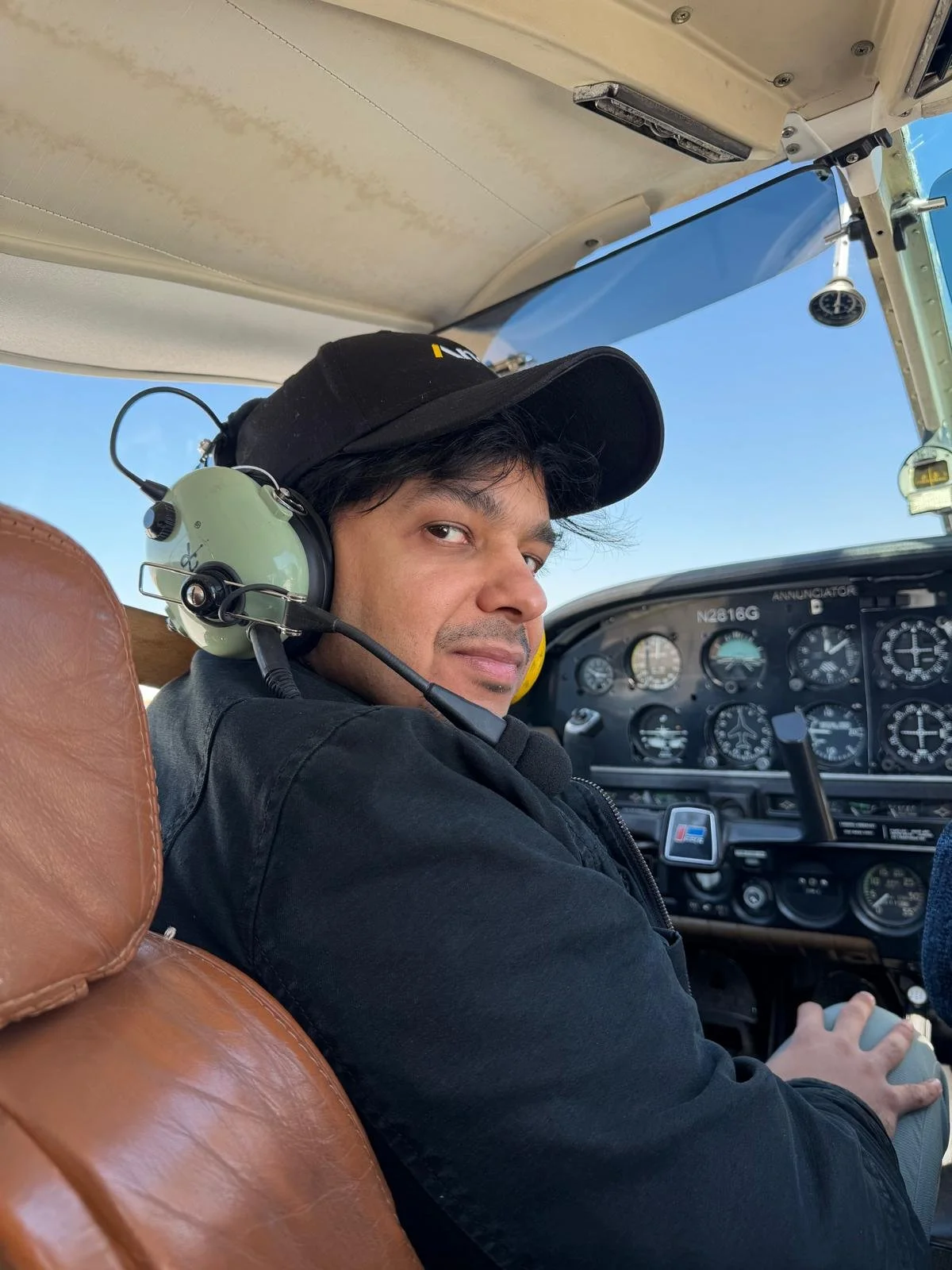 Shahmeer looks over his shoulder while piloting a plane.