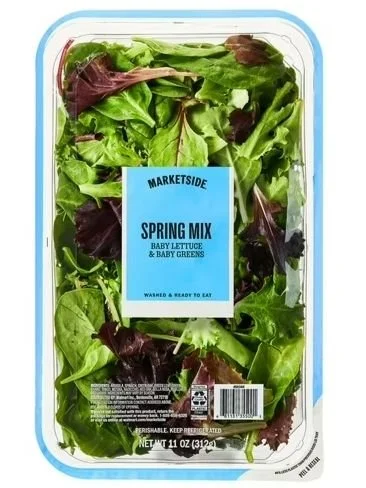 A plastic clamshell of store-bought organic spring mix lettuce